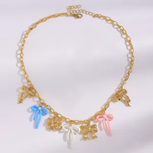 Detailed view of colorful enamel bowknot pendants on a gold chain necklace