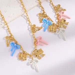 Detailed view of colorful enamel bow pendants on a shiny gold-tone chain necklace