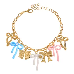 Detailed view of colorful enamel bow charms on a gold-tone link chain necklace.