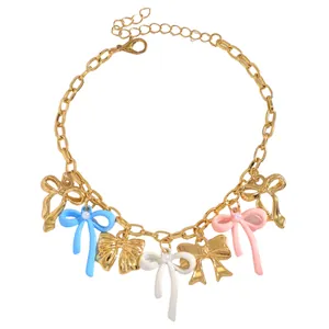 Detailed view of a gold-toned chain with colorful enamel bow charms and pearls
