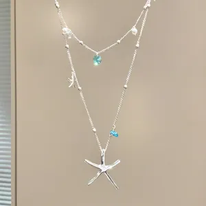Detailed view of silver double-layer necklace with starfish pendants and blue crystal