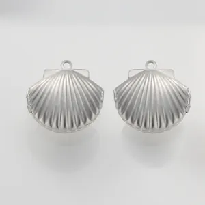 Detailansicht von zwei silbernen Medaillons in Muschelform für DIY-Schmuck.