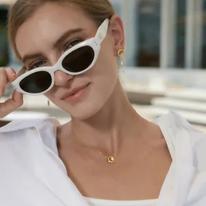 Detailed view of model wearing gold-toned minimalist necklace and matching earrings