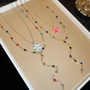 Dettaglio di collane a Y con perline di cristallo colorate e fiori smaltati