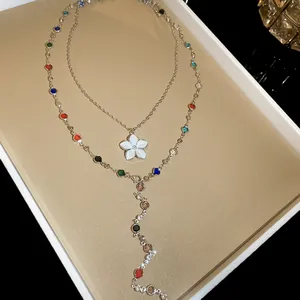 Dettaglio delle perle di cristallo colorate e del ciondolo a fiore bianco su questa collana
