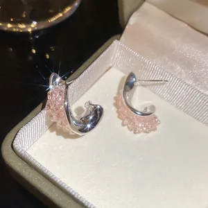 Elegante silberne Creolen mit schimmernden rosa Kristallen in einer luxuriösen Schmuckschatulle.
