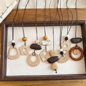 Boho Handgewebte Halsketten mit Holzperlen und Blumenanhängern auf Holzdisplay