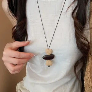 Detailansicht einer langen Boho-Halskette mit gewebten Herzperlen und dunklem Stein
