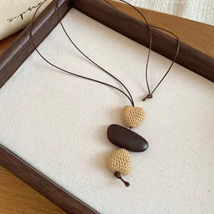 Detail einer Boho-Halskette mit gewebten Herzperlen und braunem Glattstein-Anhänger.