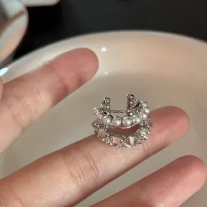 Vue détaillée d'un earcuff multicouche orné de perles élégantes et de zircons brillants.