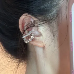Détail d'un earcuff multicouche argenté avec perles blanches et oxydes de zirconium brillants