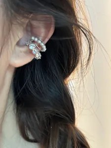 Vue détaillée d'une boucle d'oreille multicouche avec perles blanches et zircons brillants.
