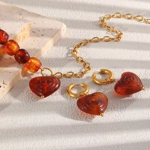 Close-up of vintage heart jewelry set with amber acrylic spirals and gold plating