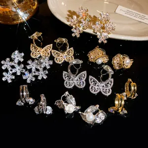 Macro detail of sparkly zircon butterfly and flower-shaped clip-on earrings for women