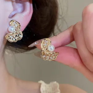 Detailed macro shot of elegant butterfly ear clips with pearls and sparkling zircons