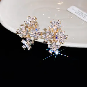 High-quality close-up of sparkly zirconia flower clip-on earrings on a white ceramic plate