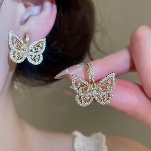 Close-up detail of exquisite zircon butterfly ear clips showing shimmering texture