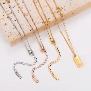 Close-up detail of 18k gold plated stainless steel gold bar necklaces on stone