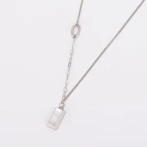 Detail of stainless steel double chain necklace with gold bar pendant