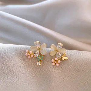 Macro view of elegant floral stud earrings with cat eye stones and sparkling crystals