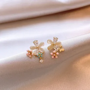 Detail view of dainty flower stud earrings with cat eye stones and crystals on silk.