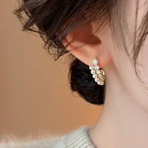 Gros plan détaillé de boucles d'oreilles en or de luxe avec perles et zircons brillants