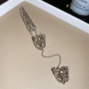 Gros plan détaillé d'une bague armure gothique évidée argentée avec chaîne style punk