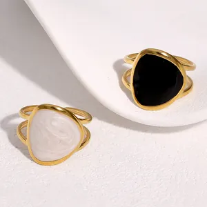 Detailed view of 18K gold-plated rings with black and pearl enamel geometric centers