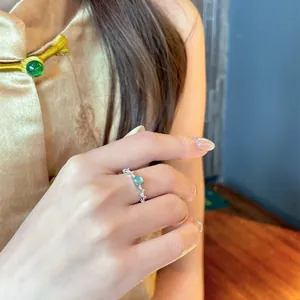 Elegante anillo de plata ajustable con circón verde redondo y acentos brillantes