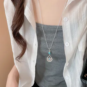 Elegante collana con ciondolo a goccia a fiore d'argento con perla turchese su modella in camicia