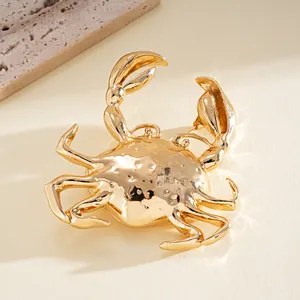 Primer plano detallado de un colgante de cangrejo de metal dorado pulido para collar