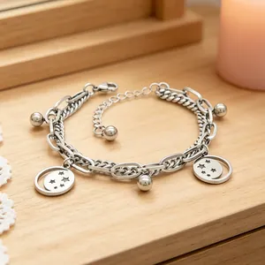 Detailed view of a silver stainless steel double-layered chain bracelet with star charms