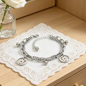 Detail view of silver stainless steel bracelet with star charms and ball drops