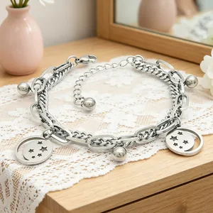 Close-up of a double-layered stainless steel bracelet with star-engraved pendants.