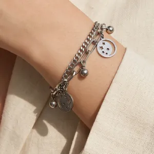Detailed view of silver double-layered stainless steel bracelet with star moon charms