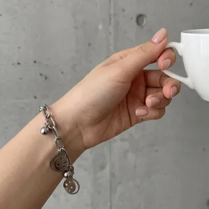 Detailed view of a silver stainless steel bracelet with star and moon charms on a wrist