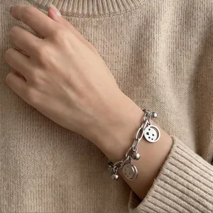 Detailed macro view of a stainless steel charm bracelet with hollow star and moon