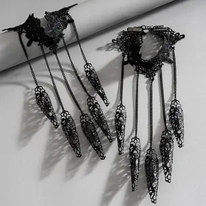 Detalle de brazalete de encaje negro gótico con anillos de armadura de dedo.