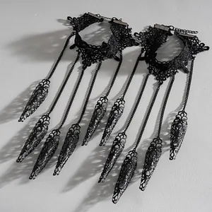 Primer plano de pulsera gótica de encaje negro con garras de metal caladas