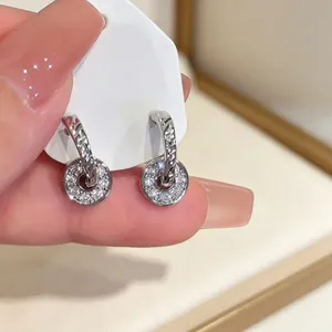 Close-up detail of silver round hoop earrings with sparkling paved stones on card