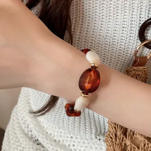 Detailansicht eines Retro-Armbands aus Acrylperlen in Bernstein und Weißtönen