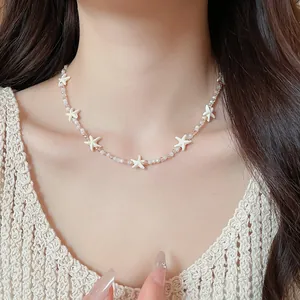 Elegante zeester en schelpkraal ketting met kristal details voor een strandvakantie stijl.