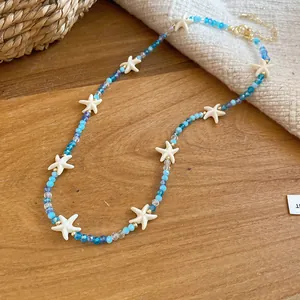 Prachtig detail van een zomerse zeester kralenketting met blauwe kristallen en schelpaccenten