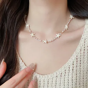 Close-up van een delicate zomerse choker met zeesterren en kristallen kralen