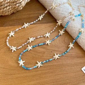 Detailopname van zomerse zeester kralenkettingen met blauwe en champagne kristallen