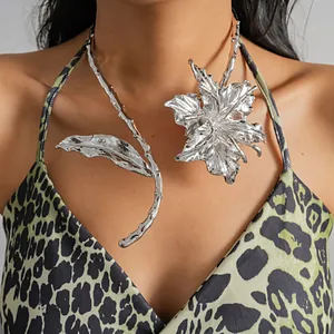 Detailed view of oversized silver metal flower and leaf choker on model.
