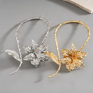 Detailed view of metallic collar necklaces featuring textured leaf and flower floral designs.