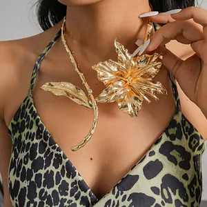 Close-up of a large gold metallic flower and leaf choker necklace with textured details