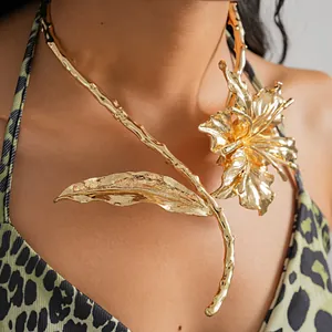 Detailed close-up of a bold gold metallic floral leaf choker necklace statement piece