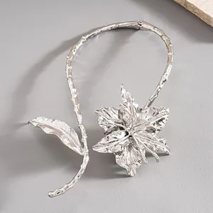 Detailed macro view of an oversized silver metallic flower choker with leaf accents.
